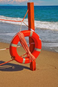 Life preserver hanging from a fence on a beach