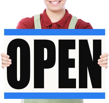 A young man wearing an apron holding a signboard indicating Open