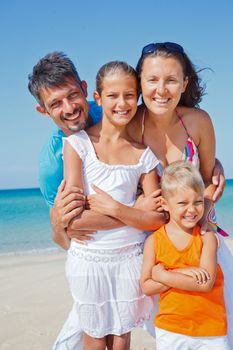 Family of four having fun on tropical beach