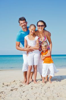 Family of four having fun on tropical beach