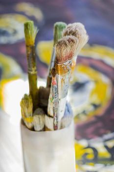 Set of paint brushes on jar, on oil painting