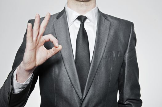 successfull businessman making ok sign, over white background