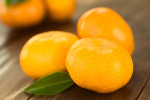 Mandarins on dark wood with leaf (Selective Focus, Focus on the front of the first mandarin) 