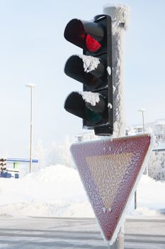 Frozen traffic light at winter showing red
