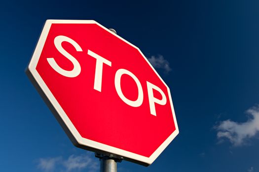 Stop sign against deep blue sky. Close up.