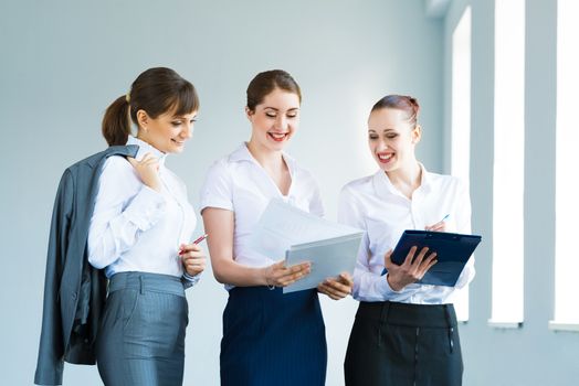 group of business women discussing documents together, teamwork in business