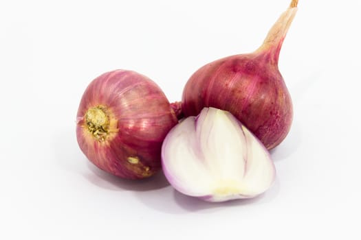 Red shallots on white background.