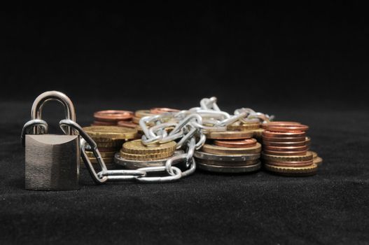 Secure Savings - a Lock and Some Coins on a Black Background
