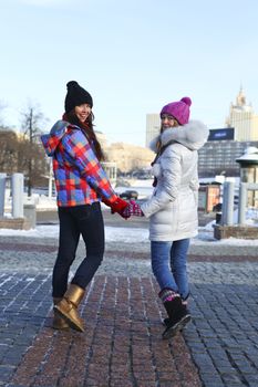 Happy young couple women in winter street