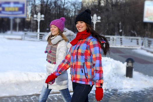Happy young couple women in winter street