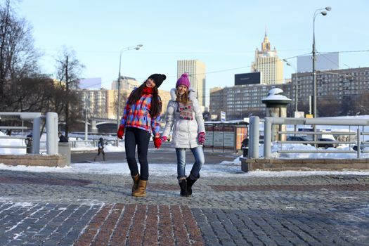 Happy young couple women in winter street