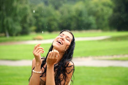 Young happy woman walking in the rain