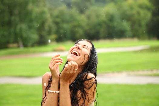 Young happy woman walking in the rain