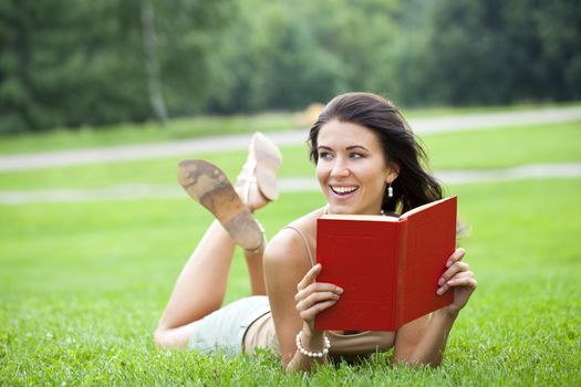 Young beautiful girl reading a book outdoor