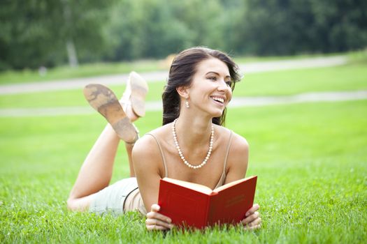 Young beautiful girl reading a book outdoor