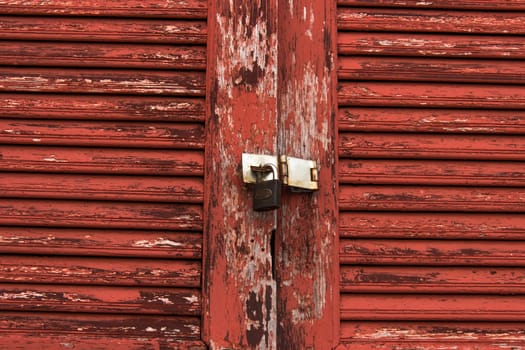 Old door red wood  peeling paint and key