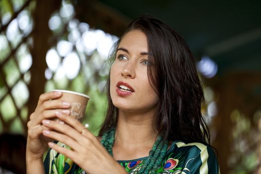 pretty young woman sitting in the cafe with a cup of tea