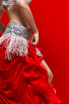 An Elegance red dress Belly dancer girl in action. With Red background