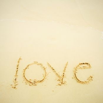 Hand written love on sand and beach