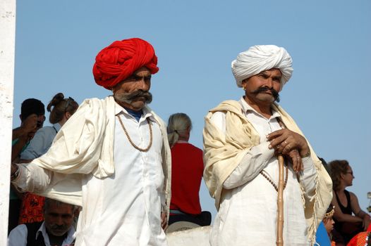 PUSHKAR, RAJASTHAN,INDIA - NOVEMBER 21: Two Rajasthani tribal men wearing traditional  turbans attend the annual Pushkar Cattle Fair on November 21,2012 in Pushkar, Rajasthan, India