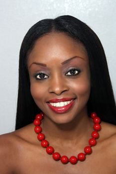 Studio close-up of an extraordinarily beautiful young woman with a bright, warm smile.