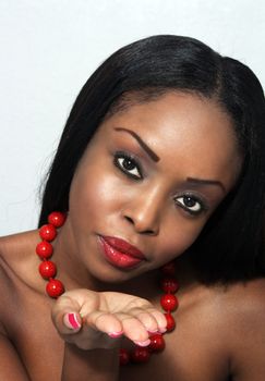 Studio close-up of an extraordinarily beautiful young woman blowing a kiss to the camera.