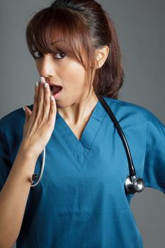 Attractive Indian doctor woman posing in a studio in front of a background