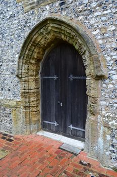 A large solid wooden oak door on a Medieval church in England,