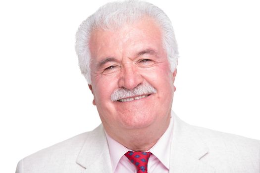 Senior white hair man with a red tie and beige suite smiling trustfully