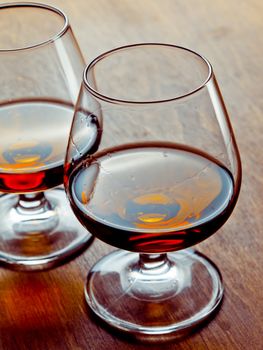 Two glasses of cognac on a wooden table