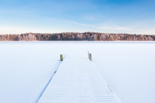 frozen snowy lake and a pier