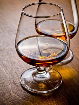 Two glasses of cognac on a wooden table