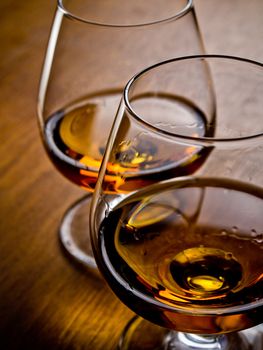 Two glasses of cognac on a wooden table