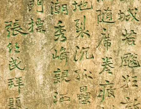 Ancient worn wall full of green chinese text