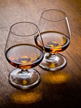 Two glasses of cognac on a wooden table