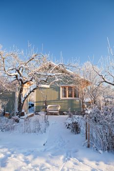 Summer cabin at winter. Clear blu sky.