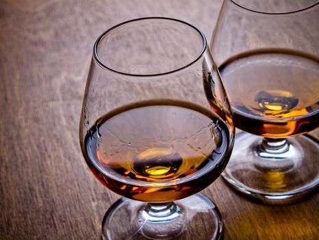 Two glasses of cognac on a wooden table