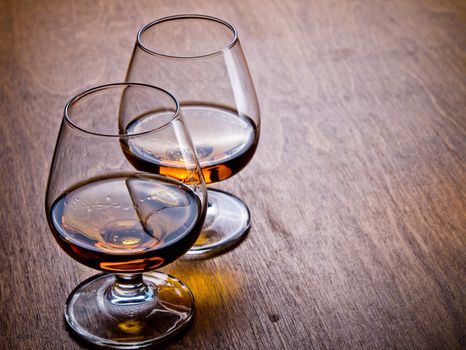 Two glasses of cognac on a wooden table