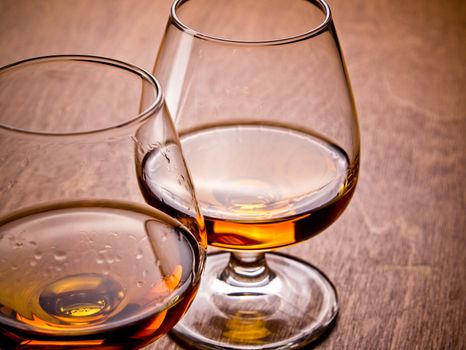 Two glasses of cognac on a wooden table