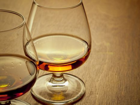 Two glasses of cognac on a wooden table