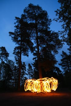 Fire spinning in forest at night