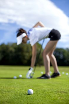 Pretty girl playing golf on grass in summer