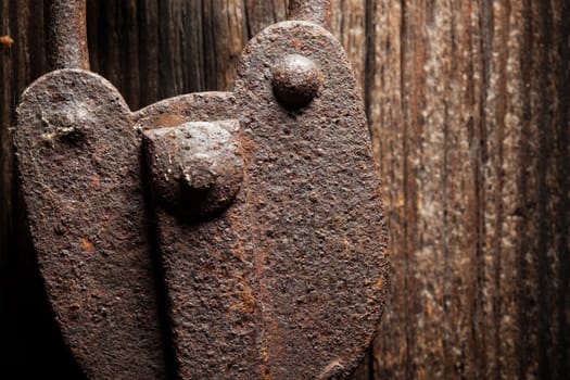 Closeup of a very old rustic padlock on a wooden door.