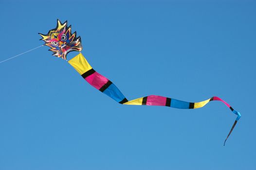 A brightly colored dragon kite against a clear blue sky