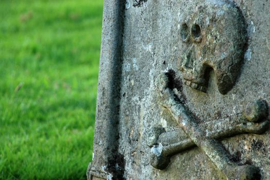 An ancient gravestone with a skull and crossbones