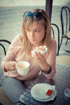 beautiful blonde woman having breakfast at the bar in the city