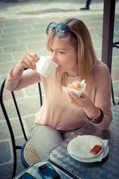beautiful blonde woman having breakfast at the bar in the city
