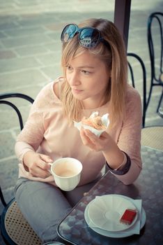 beautiful blonde woman having breakfast at the bar in the city