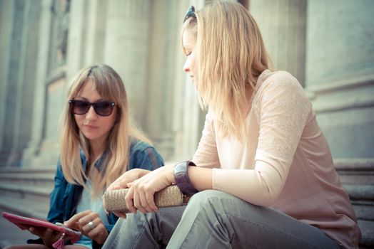 two beautiful blonde women talking in the city