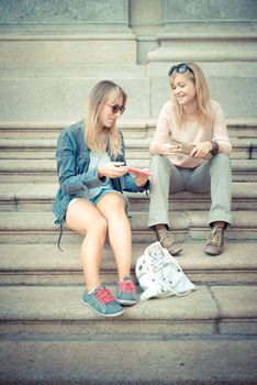 two beautiful blonde women talking in the city